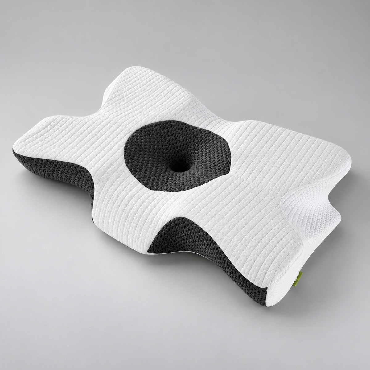 White and grey contoured cervical memory foam pillow with central head cradle on a grey background