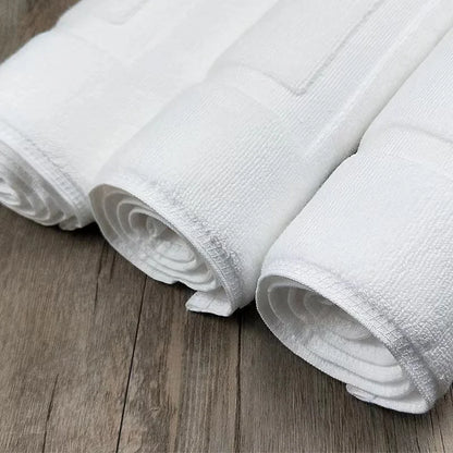 Rolled white cotton bath mats